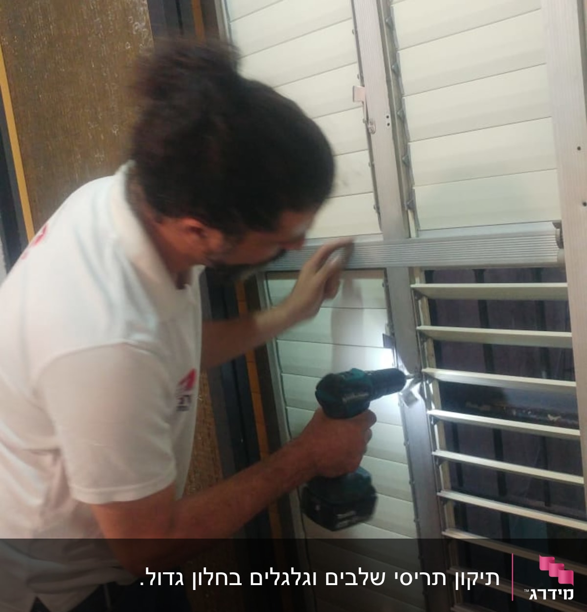 אדם מתקין תריסים עם מברגה חשמלית